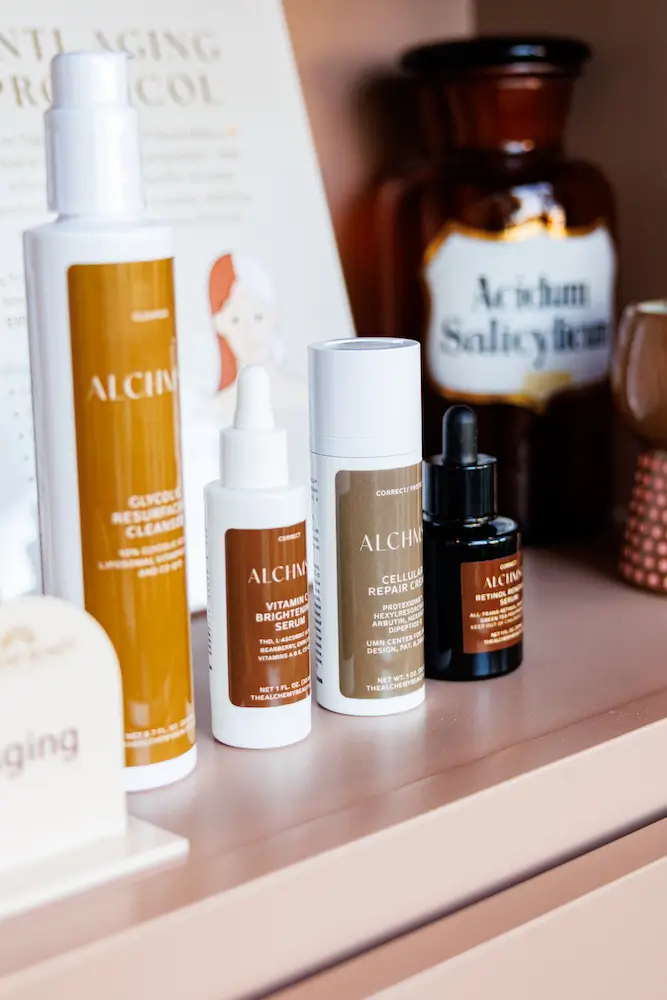 A collection of skincare products displayed on a shelf, including bottles and jars, with labels for various serums and repair creams.