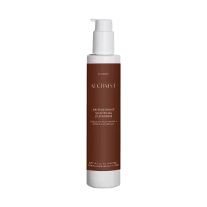 A sleek bottle of Alchimst Antioxidant Soothing Cleanser with pump top against black background, featuring green tea polyphenols, emblica, bisabolol ingredients.