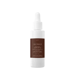 White bottle with dropper, labeled "ALCHMST Radiance Drops SPF 50," featuring zinc oxide and antioxidant complex. Contains 1 fl. oz. by The Alchemy Beauty.