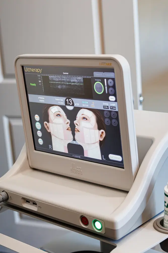 A medical device showing a facial treatment interface with diagrams of a person's face. The screen displays treatment settings and progress indicators.